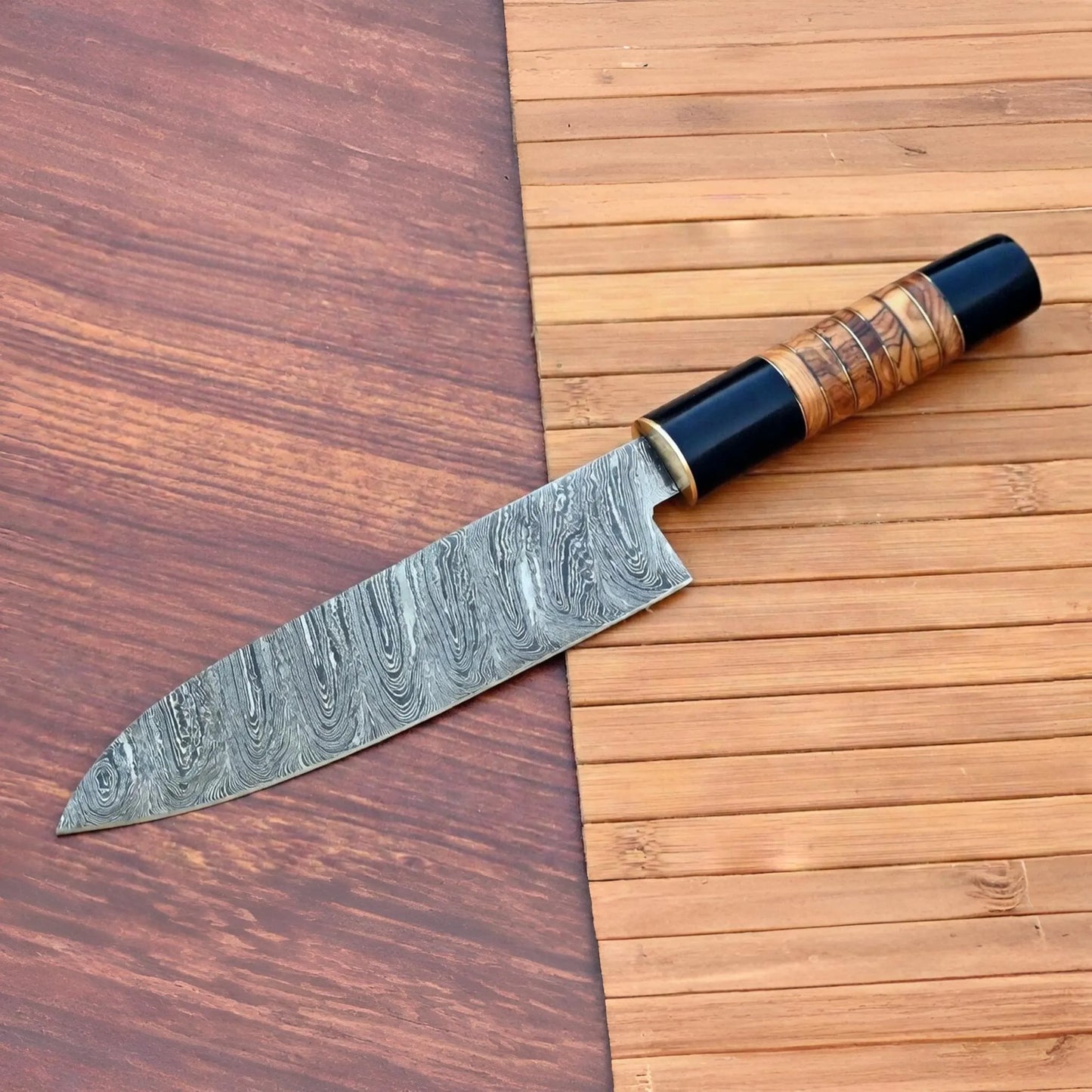 Hand forged Damascus santoku knife showing twist pattern blade and full tang construction