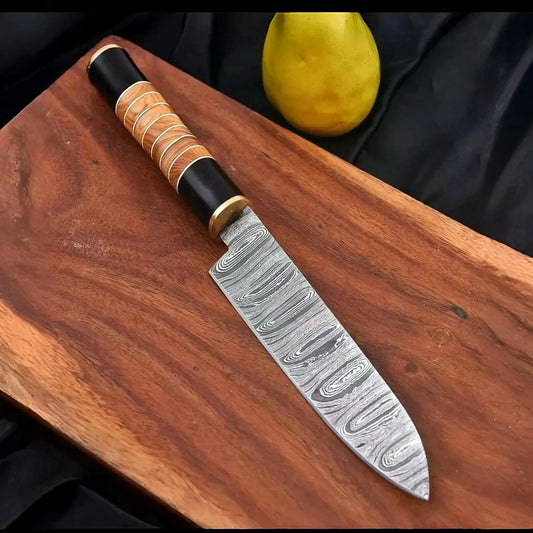 7.5 inch hand forged Damascus santoku knife with twist pattern blade and olive wood handle on cutting board